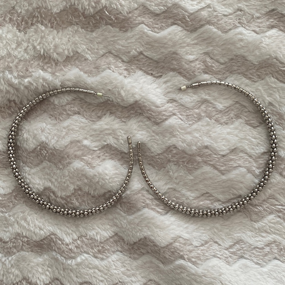 Very large silvertoned open back hoop earrings about 4 inch. Post closure.